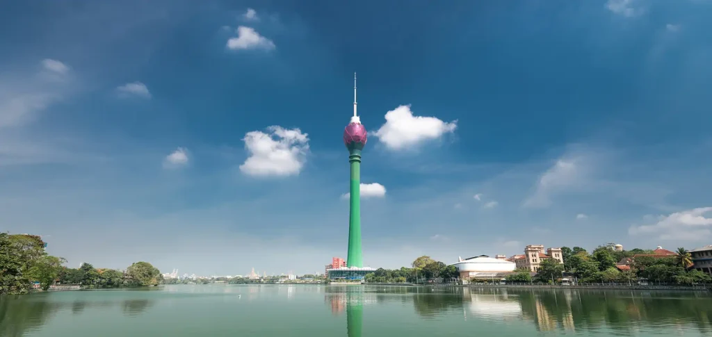 The modern Colombo Lotus Tower reflecting in the calm waters of Beira Lake, a stunning capital city landmark to visit when you book Sri Lanka day excursions.